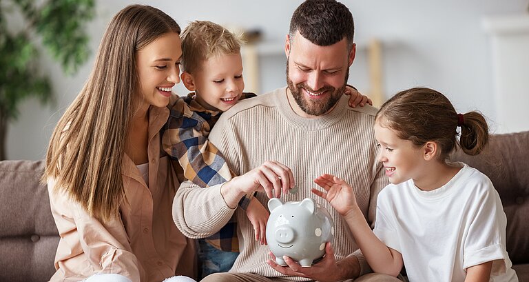 Familie steckt Geldmünzen in Sparschein