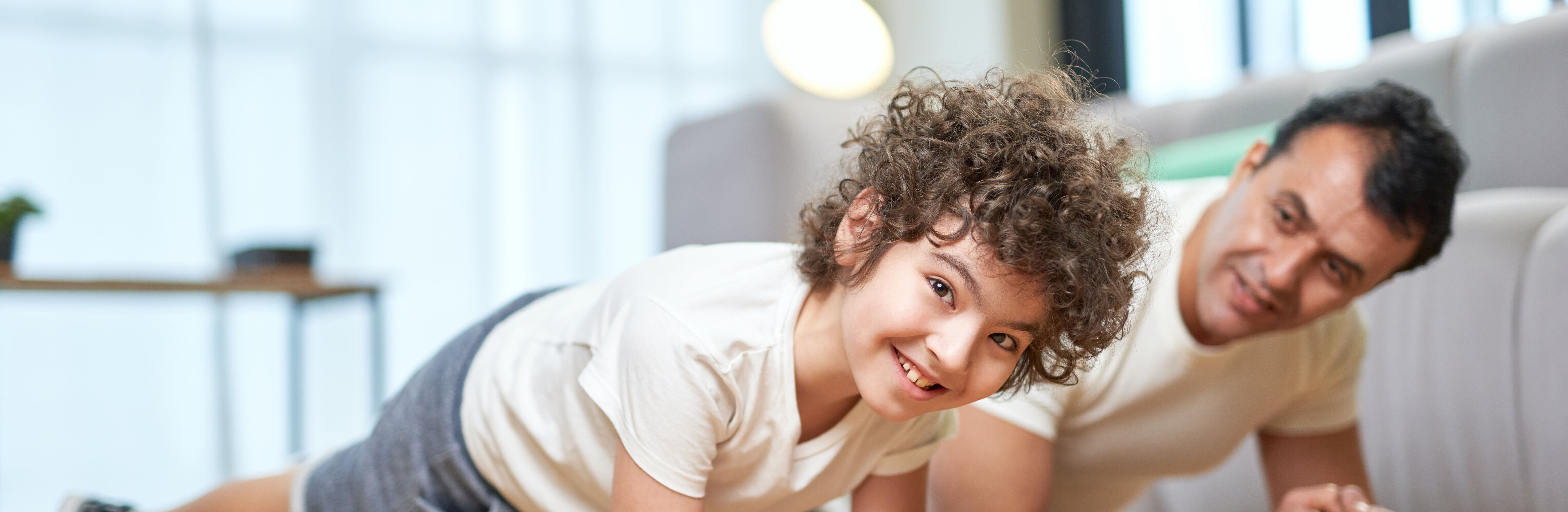 Vater und Sohn machen Situps im Wohnzimmer